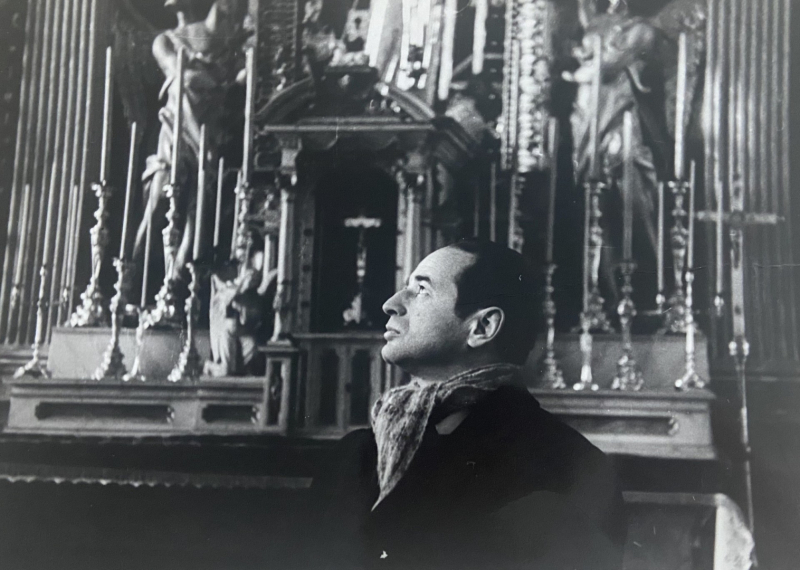 Melnbalts Herca Franka portrets baznīcas interjerā, lūkojamies augšup uz greznu altāri.