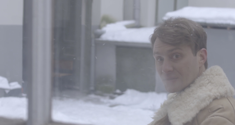 Vīrieša portrets miglainā gaismā ziemas pilsētvidē.