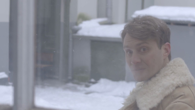 Vīrieša portrets miglainā gaismā ziemas pilsētvidē.